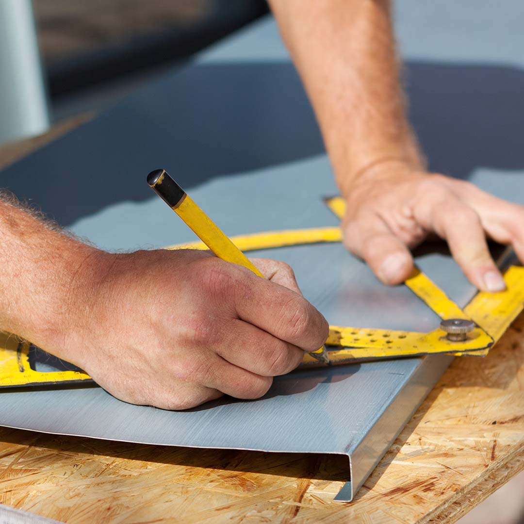 Man making marks and calculations on metal