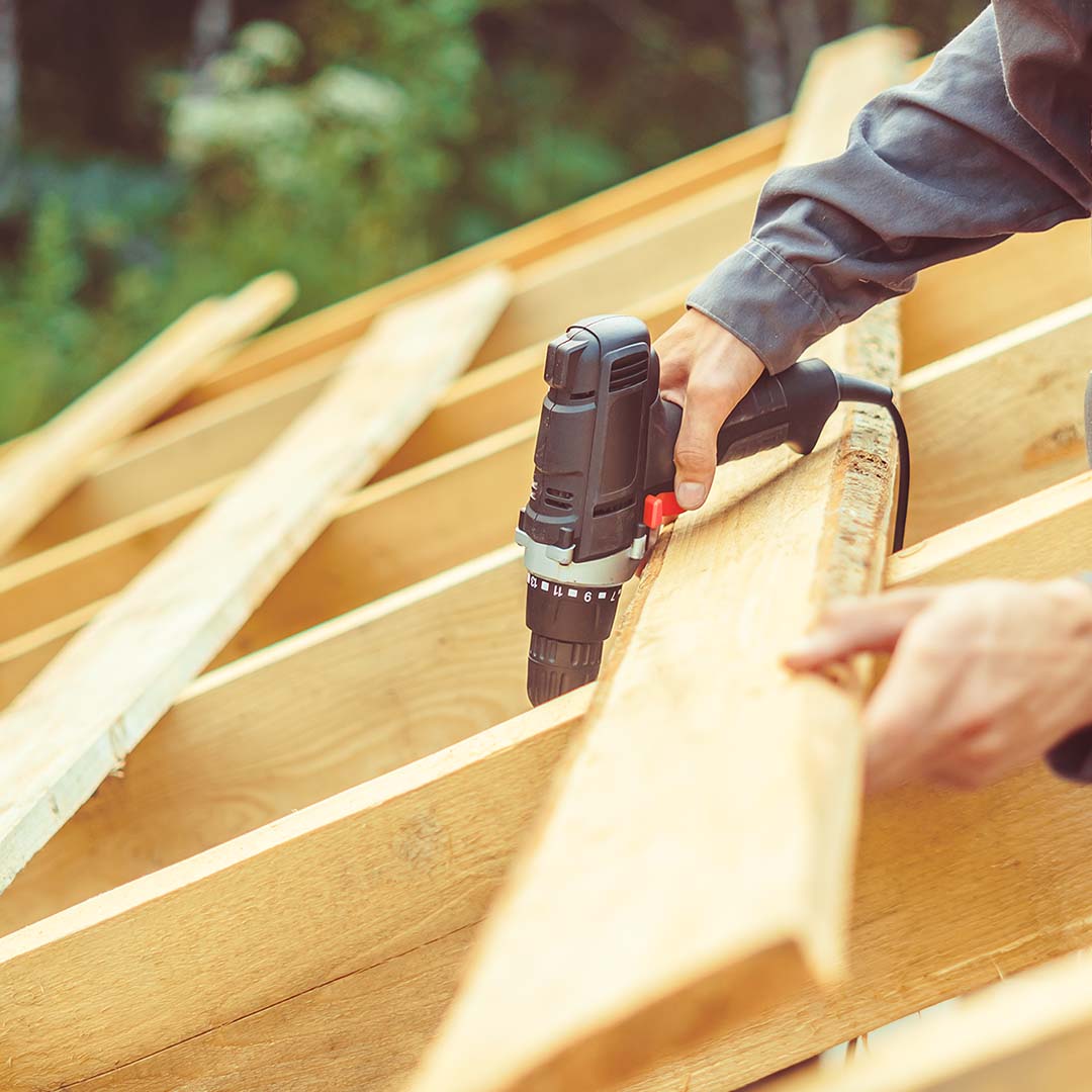 Man using power tool on roof